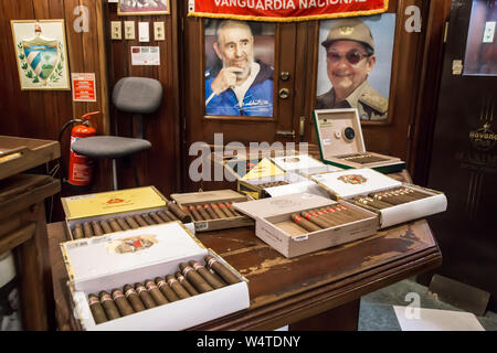 Tavolo pieno di scatole di sigari in Romeo y Julieta cigar shop. Foto di Fidel e Raul Castro in background. Foto Stock