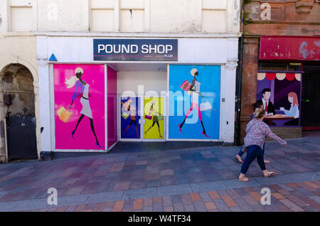 Le persone passano da svuotare unità di vendita al dettaglio in High Street in Dumfries Scozia UK. Illustrazione è stata dipinta su di loro come loro non sono state lasciate per un certo periodo di tempo Foto Stock