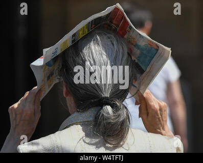 Leipzig, Germania. Xxv Luglio, 2019. Per proteggersi dal sole cocente, un passante in Lipsia Centro città tiene un giornale sopra la testa per proteggersi dal caldo estivo. Credito: Jens Kalaene/dpa-Zentralbild/dpa/Alamy Live News Foto Stock