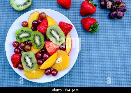 Vegetariano Sano frutta fresca insalata estiva con dessert arance, fragole, kiwi, pesche e uva Foto Stock