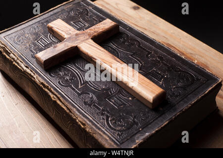 Vecchio Sacra Bibbia in legno con una croce cristiana Foto Stock