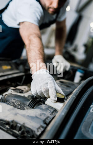 Vista ritagliata della autofficine toccando il cappello in automobile Foto Stock