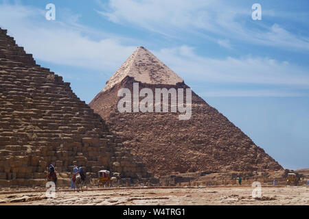 Le grandi piramidi di Giza con persone a cavallo di cammelli. Foto Stock