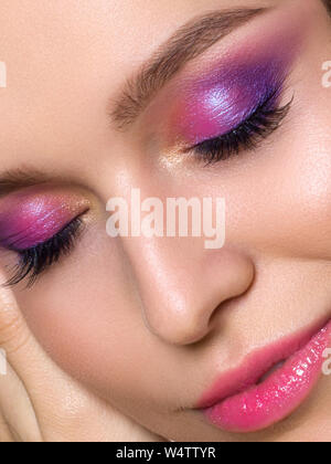 Close up bellezza ritratto di Giovane bellissimo modello con rosa smokey eyes make up. Bright primavera o estate moderna moda make up. Le labbra rosa e smokey Foto Stock