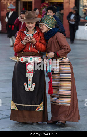 Cina, Tibet, Lhasa, due giovani Khamba donne tibetane dal Kham regione del Tibet orientale su un pellegrinaggio per visitare luoghi santi uno indossa uno stile occidentale cappello in feltro che è molto popolare nella regione del Kham l'altro indossa una veste più traditiional hat e bandian o pangden grembiule. Foto Stock