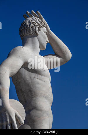 Statua di un discus thrower in Stadio dei Marmi (Marmo Stadium) in Roma. La statua ha la sua mano alzata, esaminando la distanza con un cielo blu Foto Stock