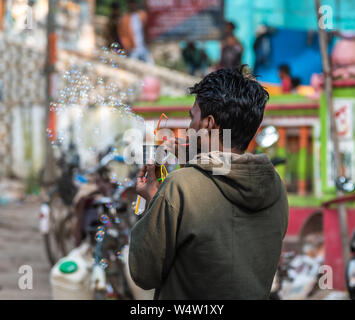Un non identificato indiana rurale venditore di soffiatura e la vendita di bolle di sapone con bolla di ventilatore. Foto Stock