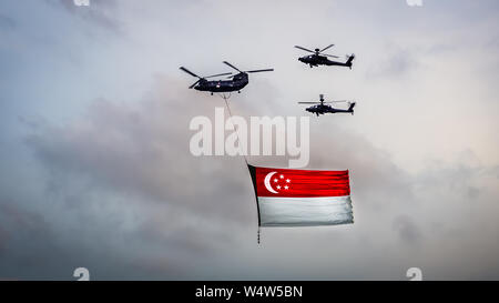 Singapore - Luglio 14, 2018: Chinook battenti un gigante Bandiera di Singapore scortato da due elicotteri Apache su Marina Bay come parte di Singapore Giornata Nazionale Pa Foto Stock