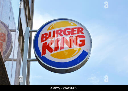 Mannheim, Germania - Luglio 2019: il Logo di burger fast food 'Burger King' appeso al di fuori di fronte blu cielo Foto Stock