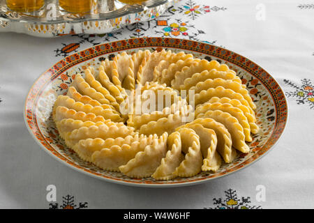 Wth piatto tradizionale marocchino festosa gazzella corna e tè su una tovaglia ricamata Foto Stock