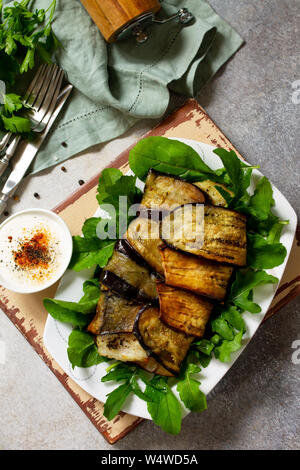 Delizioso pesce al forno con verdure in un melanzane alla griglia su una pietra o ardesia tabella. Vista superiore piatta. laici Foto Stock