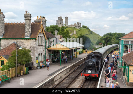 Corfe Castle, Regno Unito - 8 Luglio 2017 : un restaurato Treno a vapore che arrivano alla stazione ferroviaria nel villaggio di Corfe Castle in Dorset, Regno Unito. Foto Stock