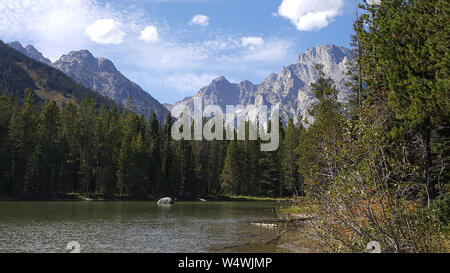 Un bellissimo lago di montagna con il torreggiante Grand Tetons in background. Foto Stock