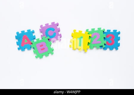 Alfabeto puzzle con numero puzzle su sfondo bianco. Vista superiore Foto Stock