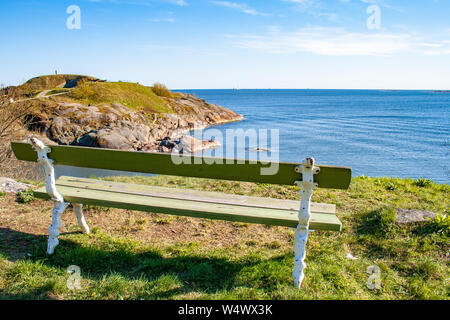 Bellissimo paesaggio finlandese, Suomenlinna, Helsinki, Helsingfors, Uusimaa, Finlandia con rocce e mare Baltico con panca in legno Foto Stock