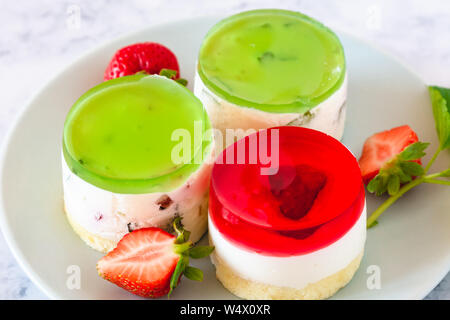 Mini rotonda la cheesecake a freddo con gelatina di frutta e le fragole. Foto Stock