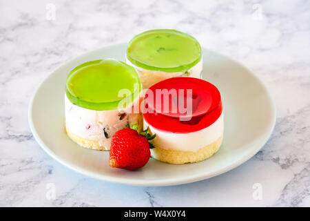 Mini rotonda la cheesecake a freddo con gelatina di frutta e le fragole. Foto Stock