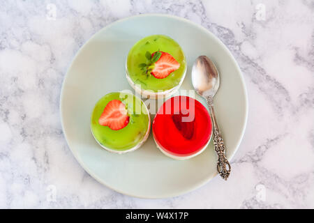 Mini rotonda la cheesecake a freddo con gelatina di frutta e le fragole. Foto Stock