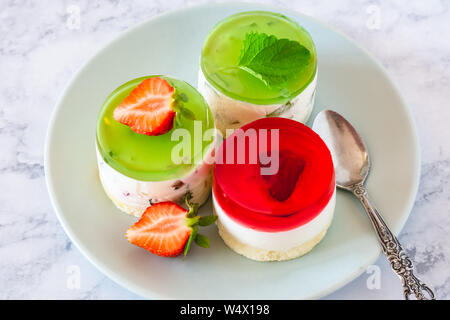 Mini rotonda la cheesecake a freddo con gelatina di frutta e le fragole. Foto Stock