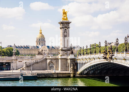 Il pont Alexandre III sul fiume Senna a Parigi, Francia, con la cupola des Invalides in background su una soleggiata mattina d'estate. Foto Stock