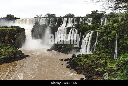 Potente acqua di gushing delle cascate multiple di Iguazu Falls, Argentina in una giornata di sole Foto Stock