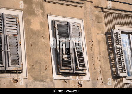 Vecchia chiusa persiane di legno sulla casa in rovina con charme mediterraneo Foto Stock