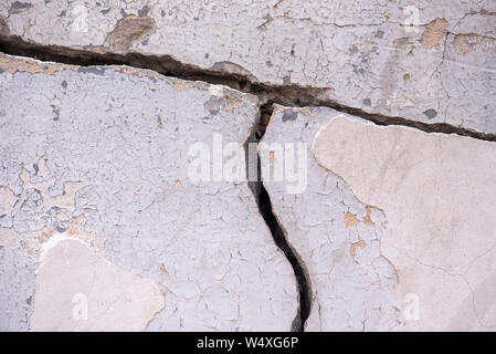 Il vecchio muro di cemento con una profonda spaccatura grande come sfondo o texture Foto Stock