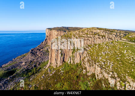 Fair Head big cliff e operazioni automatiche di fine campo all'angolo nord-est della Contea di Antrim. Irlanda del Nord, Regno Unito. Famoso luogo di arrampicata. Vista aerea in sunset paglierino Foto Stock