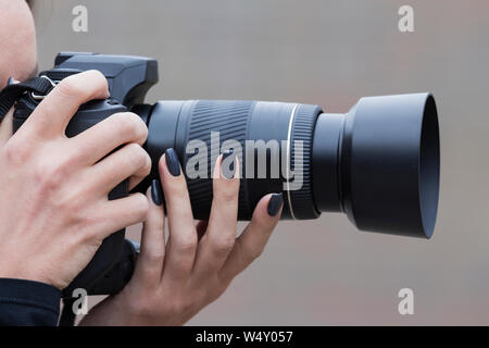 Ragazza con belle fotografie manicure sulla reflex a ottica singola telecamera Foto Stock