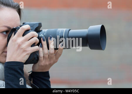 Ragazza con belle fotografie manicure sulla reflex a ottica singola telecamera Foto Stock