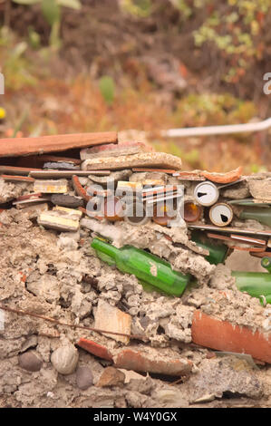 Muro di una casa in rovina formata da pietre, ARMOR, piastrelle, mattoni, bottiglie, lattine, ecc. Foto Stock