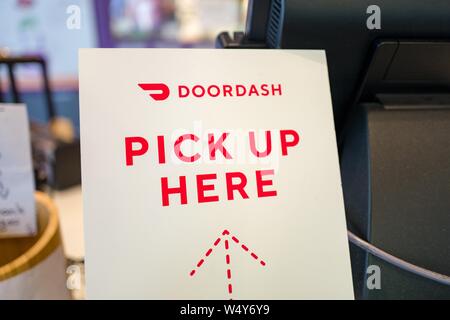 Close-up di segno per la gig economy consegna pasti app Doordash, con testo di lettura Doordash Pick up qui, in un ristorante di impostazione in Lafayette, California, 23 maggio 2019. () Foto Stock