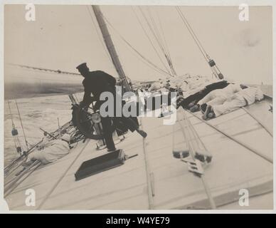 Equipaggio giacente sul lato alto a bilanciare lo yacht Reliance, vincitore del 1903 Coppa America Foto Stock