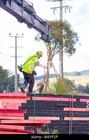 Sheffield. Canterbury, Nuova Zelanda, 25 Luglio 2019: costruttori scaricare capriate che sono stati consegnati da un carrello Hiab ad un sito di costruzione Foto Stock