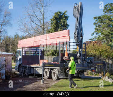 Sheffield. Canterbury, Nuova Zelanda, 25 Luglio 2019: costruttori scaricare capriate che sono stati consegnati da un carrello Hiab ad un sito di costruzione Foto Stock