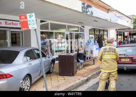 L'auto si schianta sul marciapiede e nel negozio, ufficiale vigili del fuoco in presenza, Avalon Beach, Sydney, NSW, Australia Foto Stock