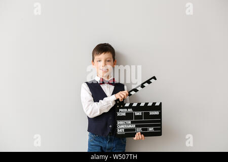 Ragazzino con clapperboard su sfondo bianco Foto Stock