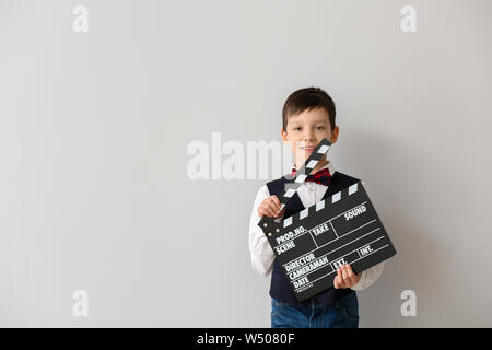 Ragazzino con clapperboard su sfondo bianco Foto Stock