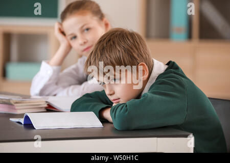 Annoiati poco i bambini durante la lezione in aula Foto Stock