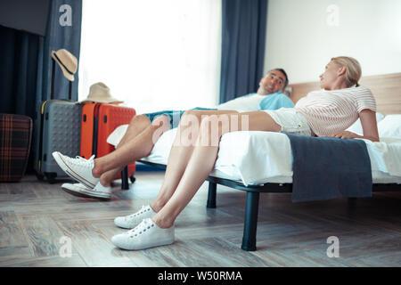 Pianificando insieme. Felice coppia sposata facendo piani sulla loro vacanza posa insieme sul letto d'hotel. Foto Stock