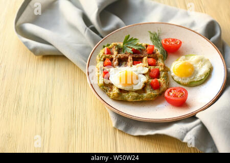 Piastra con gustosi squash waffle e uova fritte sul tavolo di legno Foto Stock