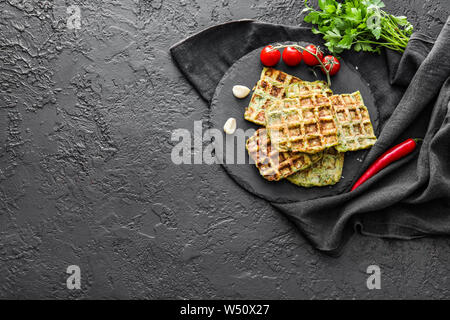 Piastra di ardesia con gustosi squash waffle su sfondo scuro Foto Stock