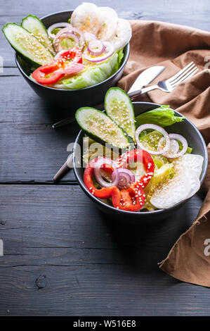 Insalata primaverile con ravanelli Cetrioli e cetriolini, cipolle, peperoni e olio di sesamo. Cibo sano. Colpo verticale Foto Stock