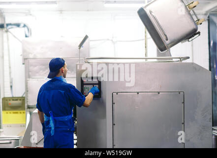 La carne nel macinatore. l'industria della carne. Foto Stock