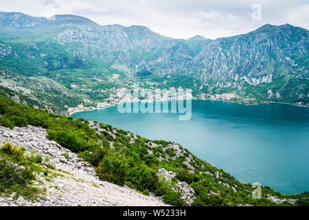 Montenegro, vista risan villaggio nella Baia di Kotor a waterside circondata da maestose montagne natura paesaggio coperto di vegetazione verde Foto Stock