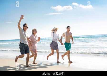 La famiglia felice in esecuzione sulla spiaggia Foto Stock