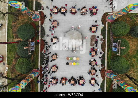 Lavoratori cinesi in costumi tradizionali a fare dieci-ton Laba Congee, o otto tesori porridge, per i visitatori in un gigante di pentola in ferro con un diamete Foto Stock