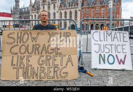 Wouter Mouton, un cambiamento climatico militante con i suoi cartoni cartelli nel centro di Bruges, Belgio. Foto Stock