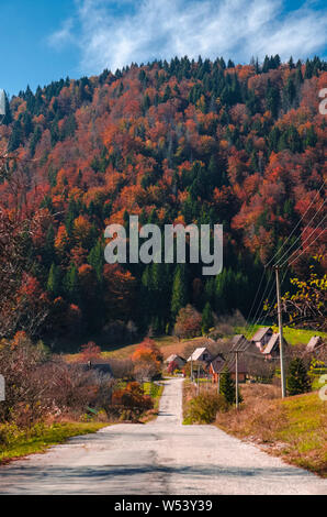 Piccolo villaggio sotto la collina accanto a un vuoto di strada panoramica Foto Stock