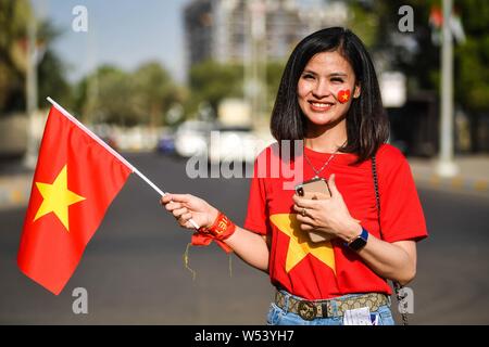 Una ventola del Vietnam può contenere fino a bandiera nazionale per mostrare il loro sostegno per il Vietnam nazionale di calcio in Asia AFC Coppa di gruppo D match tra Iraq e Vietn Foto Stock